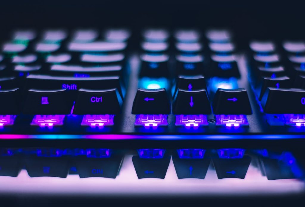 A detailed close-up of illuminated mechanical keyboard keys with focus on blue and purple lights.